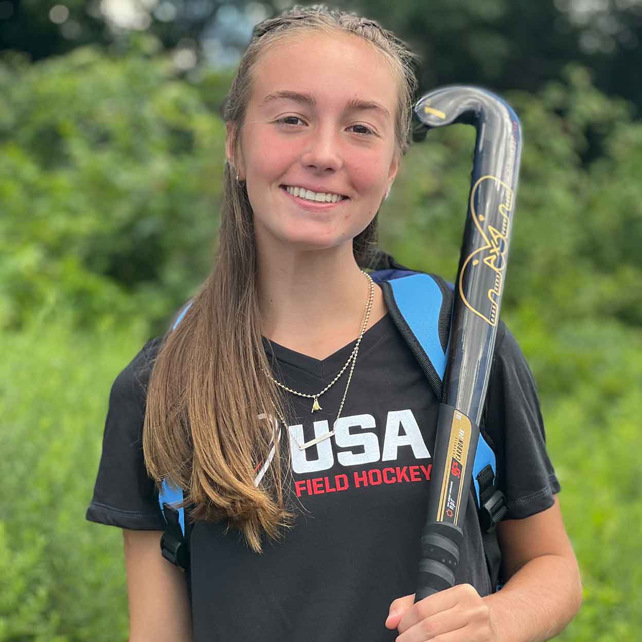 Giel holding a stick and wearing a USA Field Hockey Ladies Super Soft-Spun Poly Tee