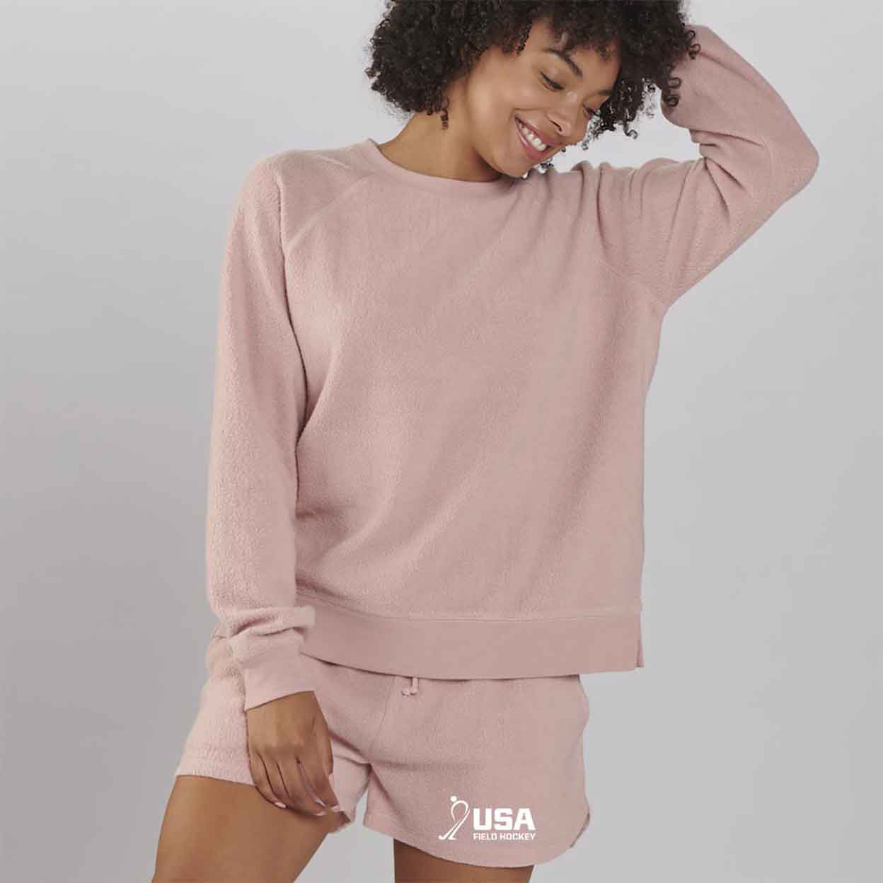 Model wearing the USA Field Hockey Fleece Out Shorts with a matching top and one hand behind her head.