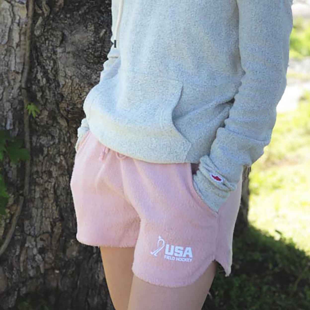 person wearing the USA Field Hockey Fleece Out Shorts with hands in the pockets.