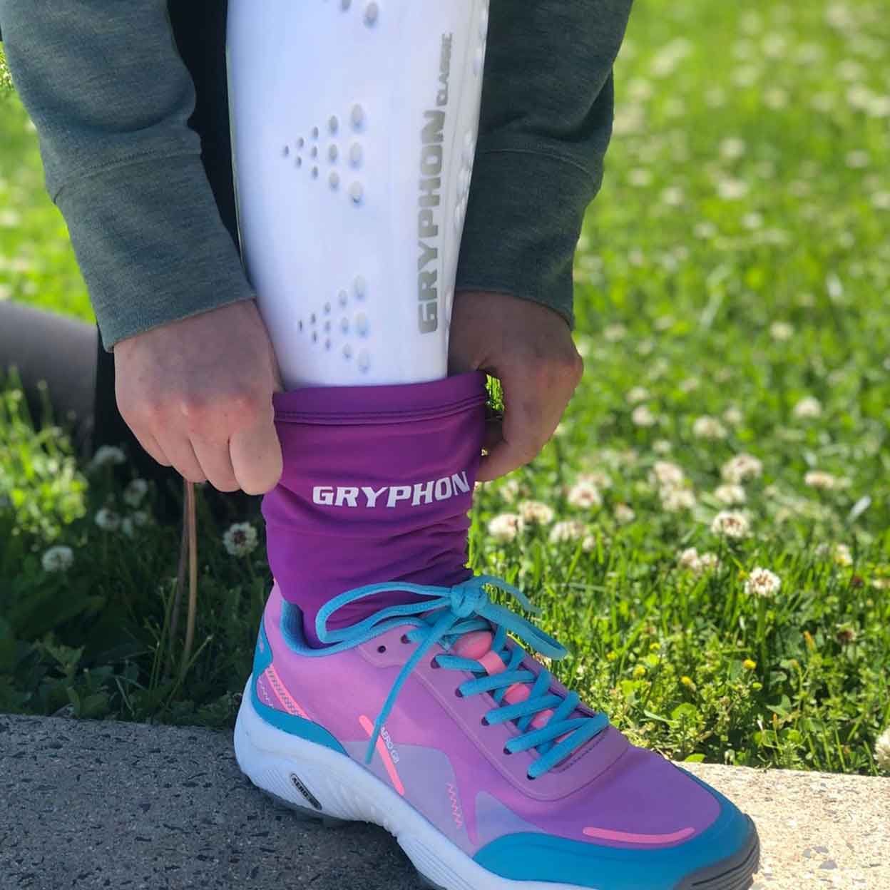 close up of a field hockey player pulling the Gryphon Shinguard Socks over a shinguard