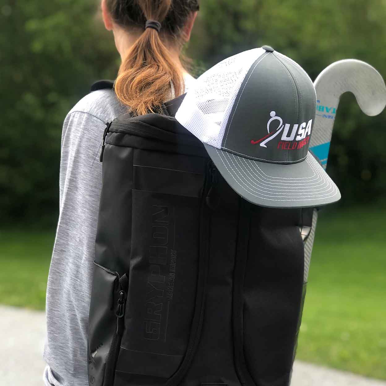 Girl with the USA Field Hockey Trucker Snapback Hat attached to her backpack