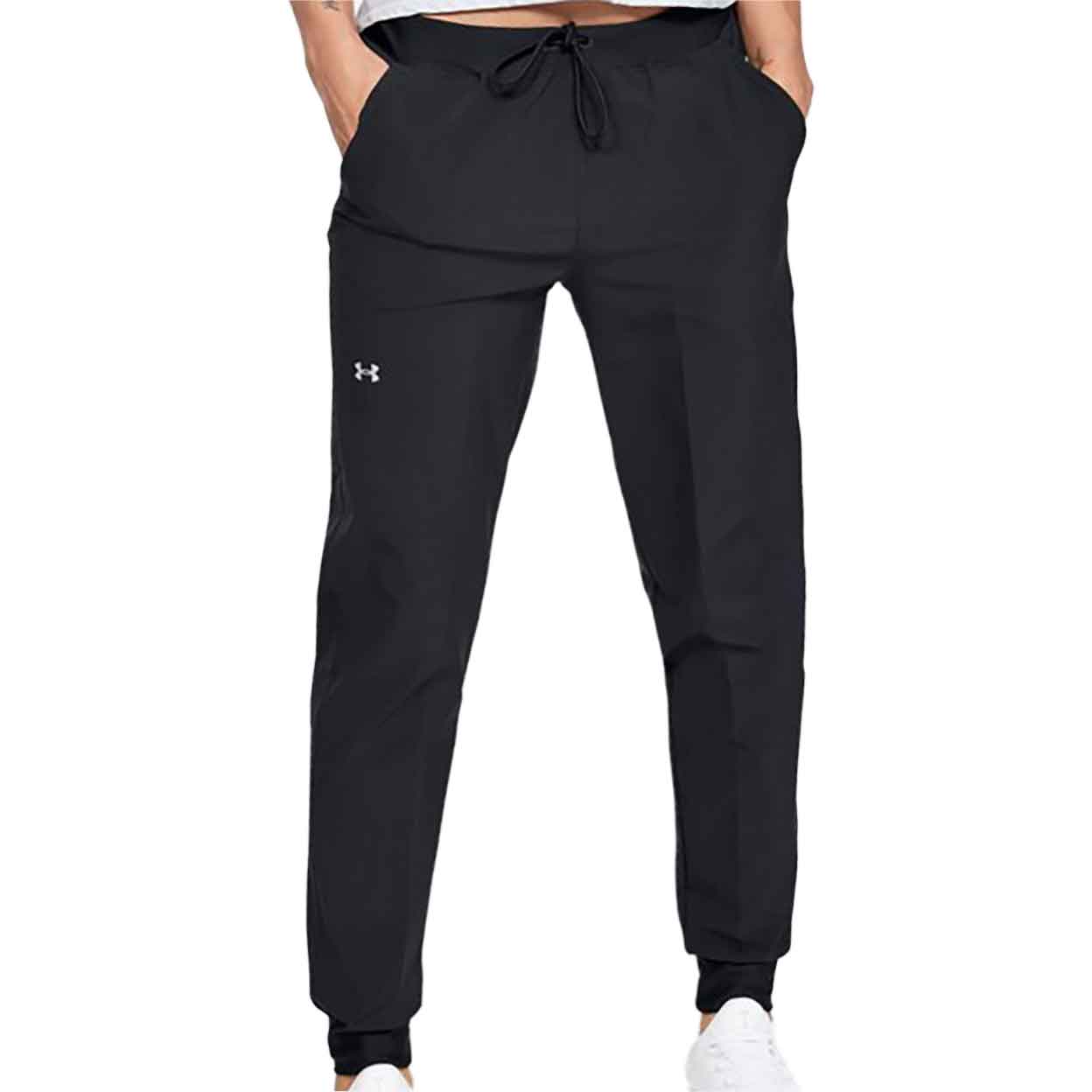 Model wearing Under Armour Women's Woven Pants hands in pockets.