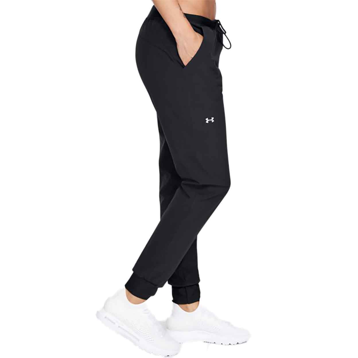 Side view of model wearing Under Armour Women's Woven Pants with hand in pocket.